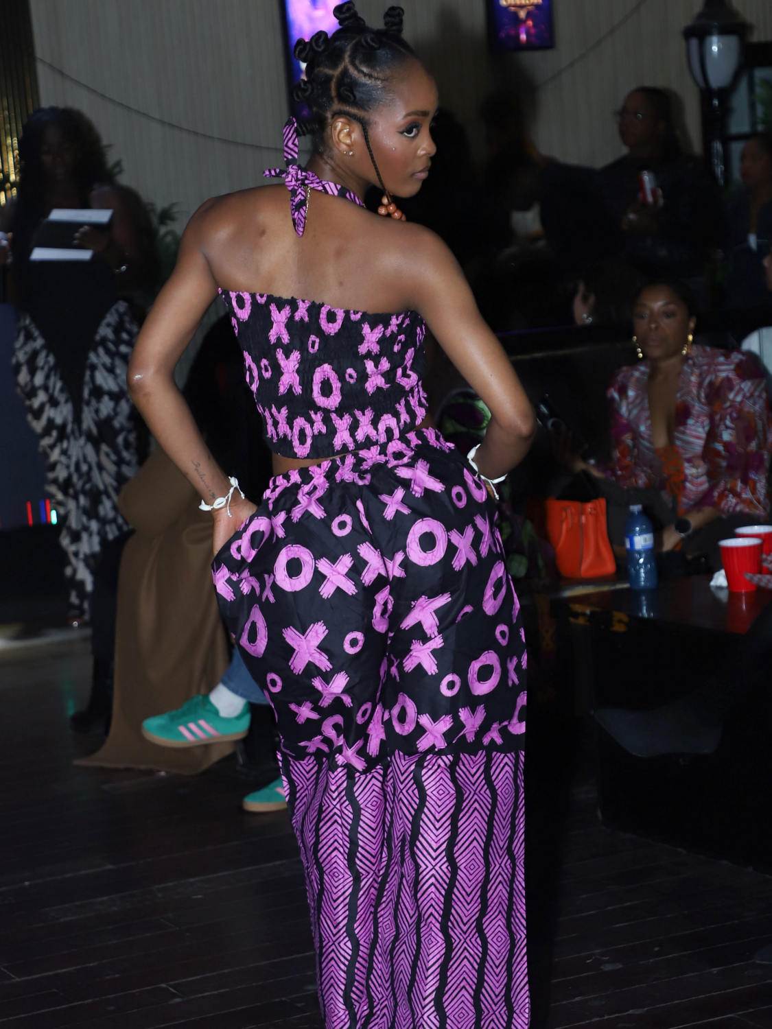 Model wearing a purple and black patterned outfit at the African Fashion Week Face of Competition 2026.